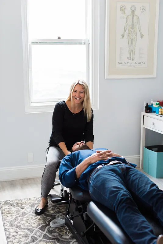Dr. Kincaid supporting a patient’s neck on the adjusting table